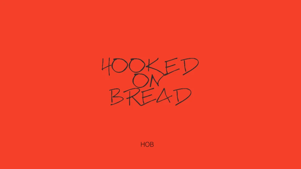 레드 배경 위 손글씨로 표현한 Hooked on Bread 브랜드 슬로건