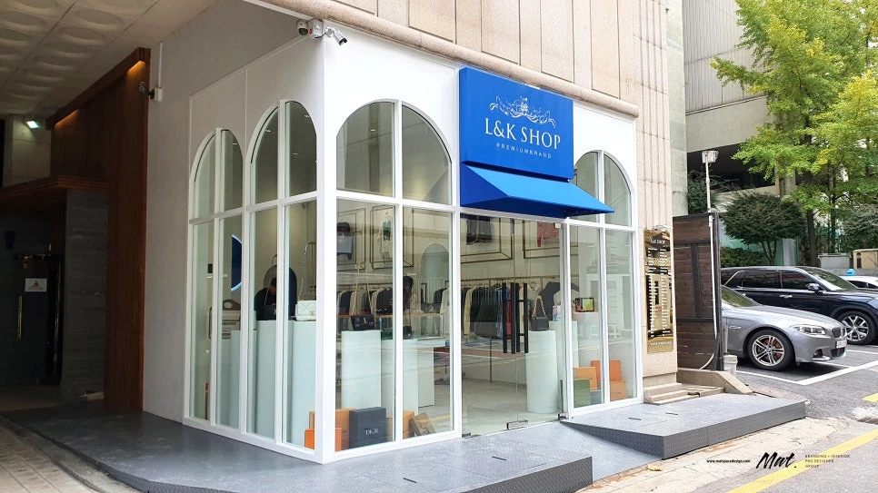 아치형 유리 파사드와 블루 사인의 L&K SHOP 패션 매장 인테리어