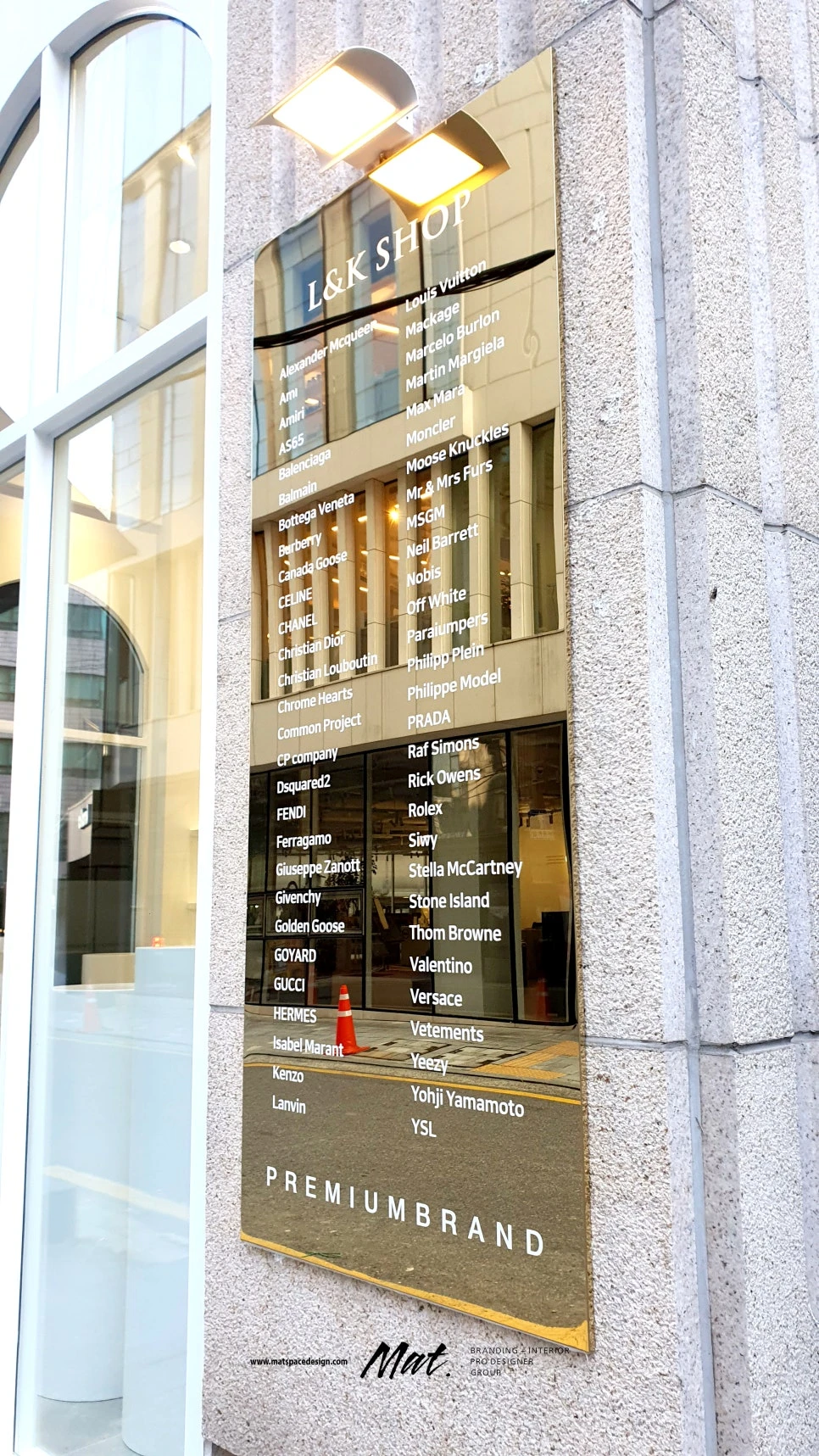 골드 미러 패널에 명품 브랜드 목록을 정리한 L&K SHOP 외부 사인