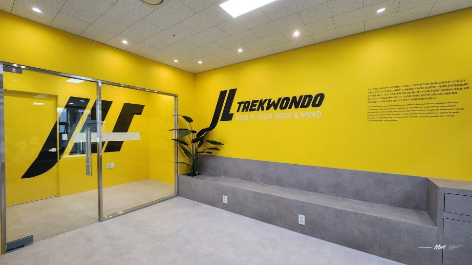 과천 제이엘태권도장 노란 브랜드 월과 계단형 대기 공간