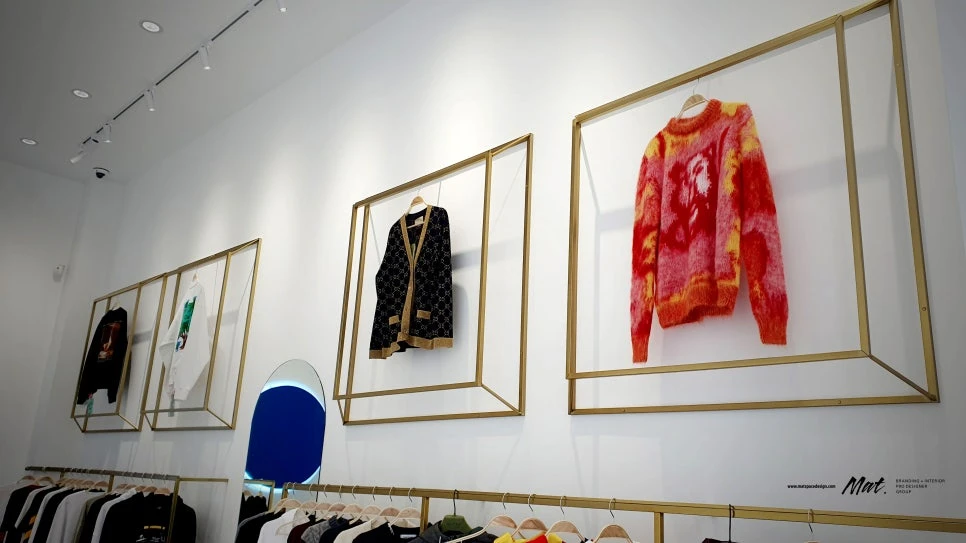 골드 프레임 안에 추천 의류를 전시한 L&K SHOP 벽면